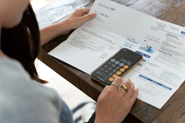 a women looking at energy bill using a calculator